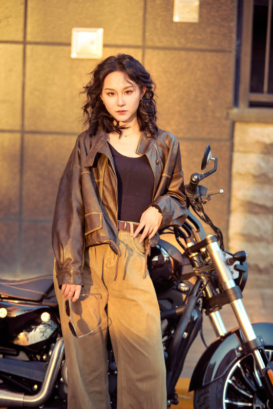 夕阳午后骑复古摩托进行拍照的东方美女图片