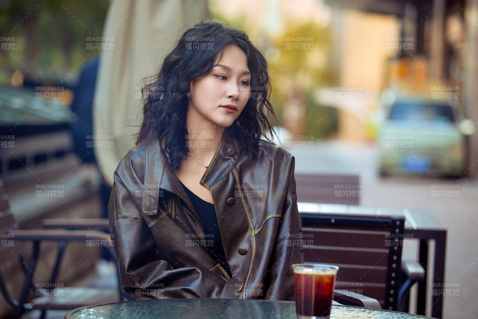 身穿复古皮衣在户外喝咖啡的东方美女图片