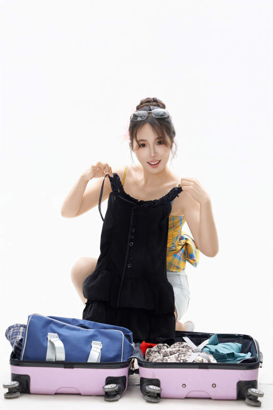 影棚拍摄收拾行李箱的青年女性形象图片