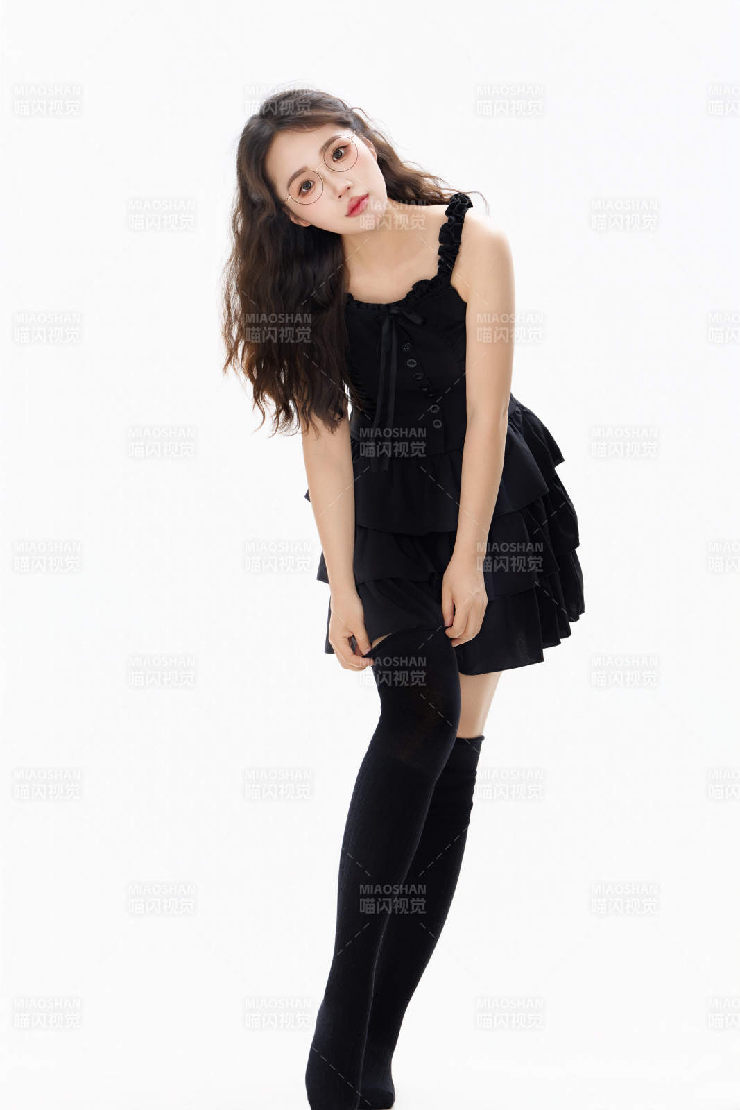 影棚拍摄穿着黑色套裙长筒袜的亚洲美女图片