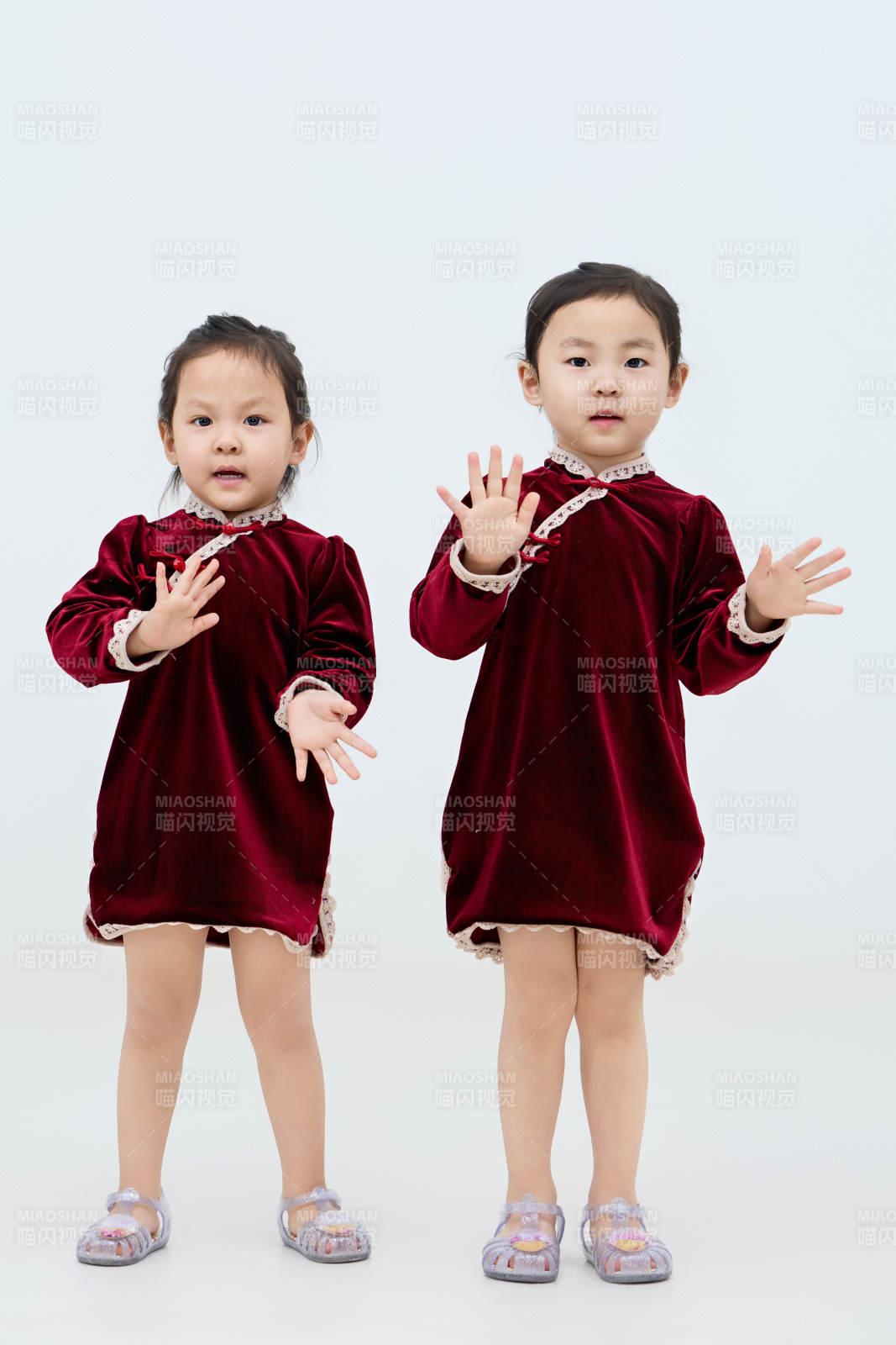 白色背景下顽皮可爱的双胞胎小女孩图片