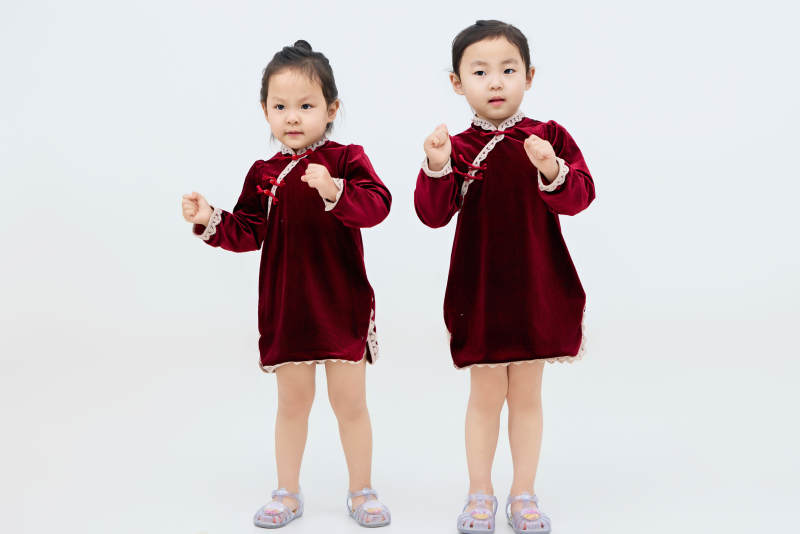 白色背景下顽皮可爱的双胞胎小女孩图片