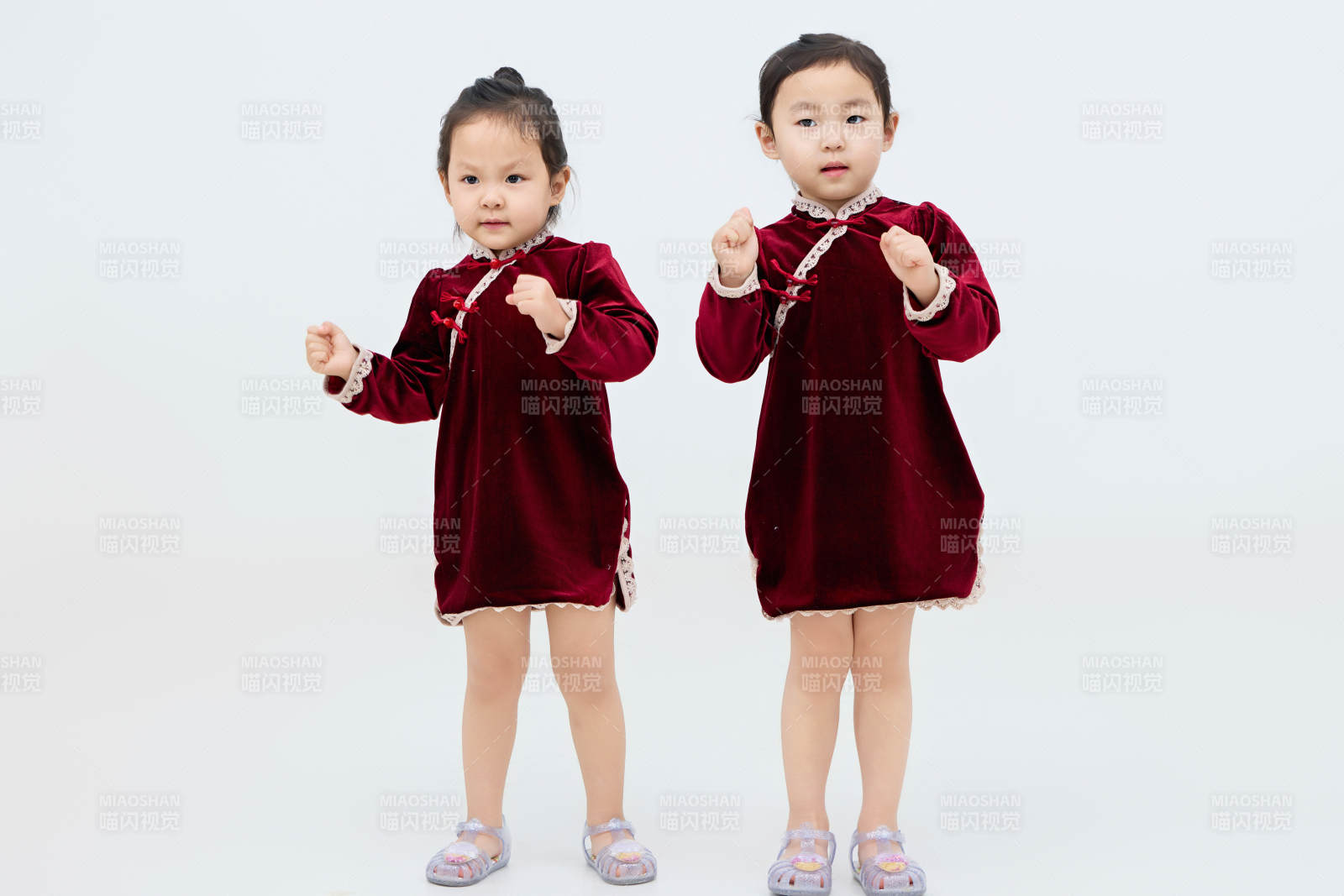 白色背景下顽皮可爱的双胞胎小女孩图片