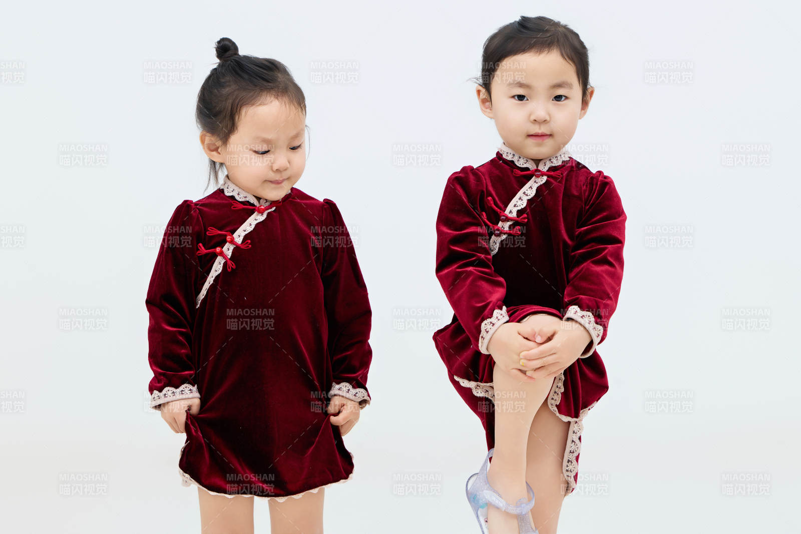 白色背景下顽皮可爱的双胞胎小女孩图片