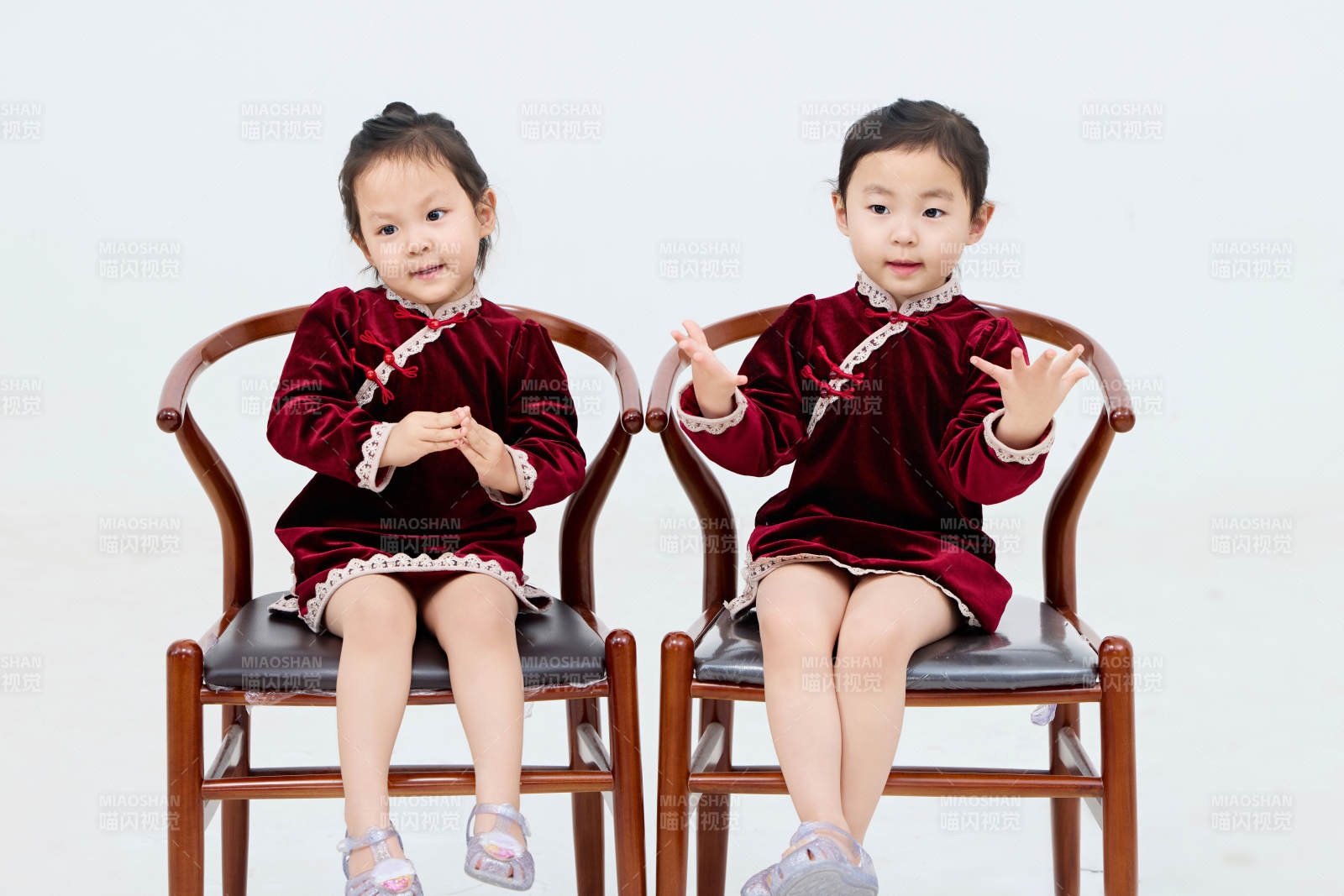 白色背景下顽皮可爱的双胞胎小女孩图片