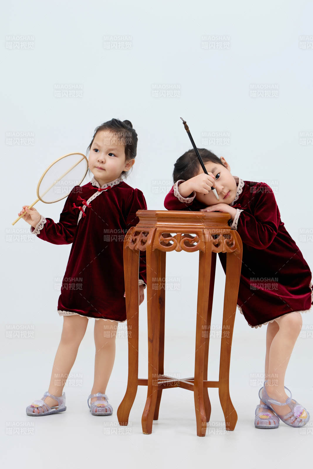 白色背景下顽皮可爱的双胞胎小女孩图片