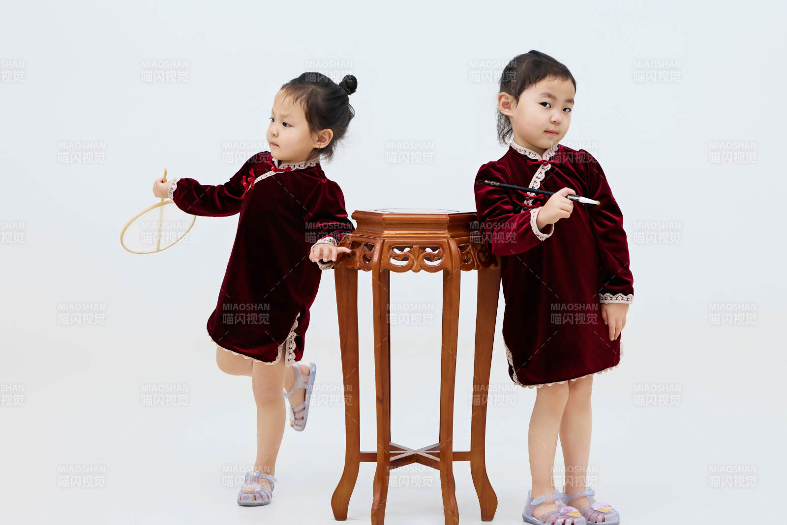 白色背景下顽皮可爱的双胞胎小女孩图片