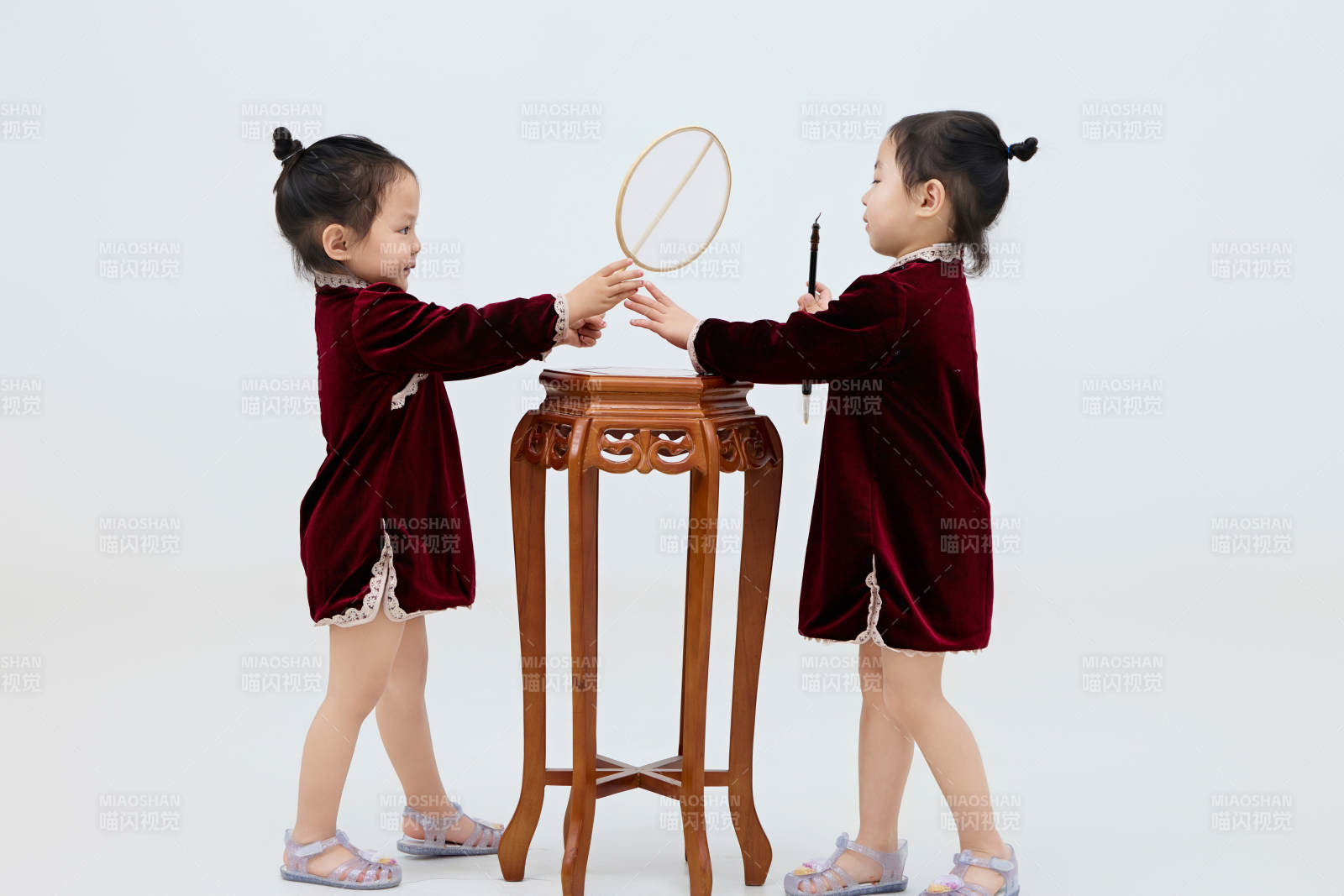 白色背景下顽皮可爱的双胞胎小女孩图片