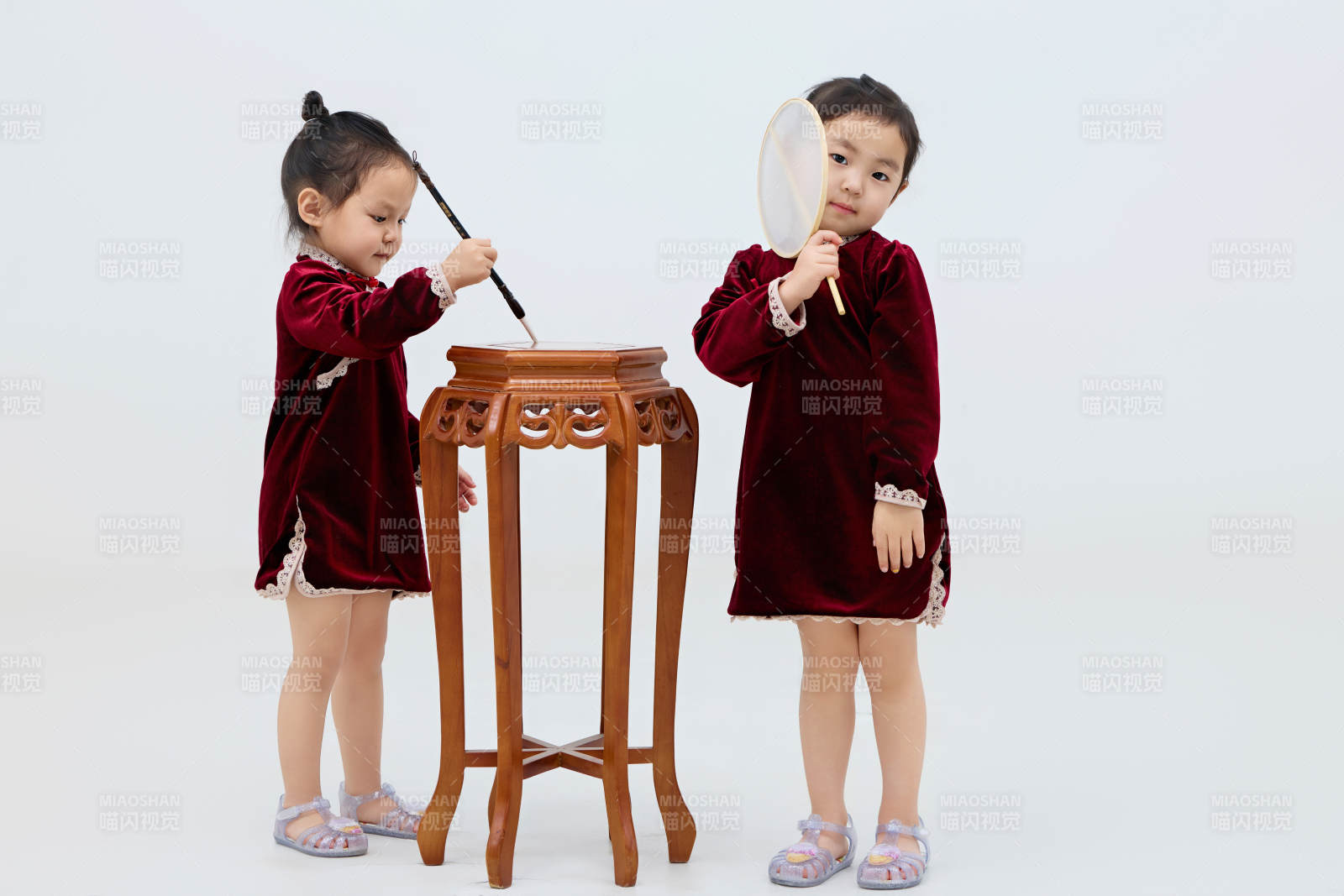 白色背景下顽皮可爱的双胞胎小女孩图片