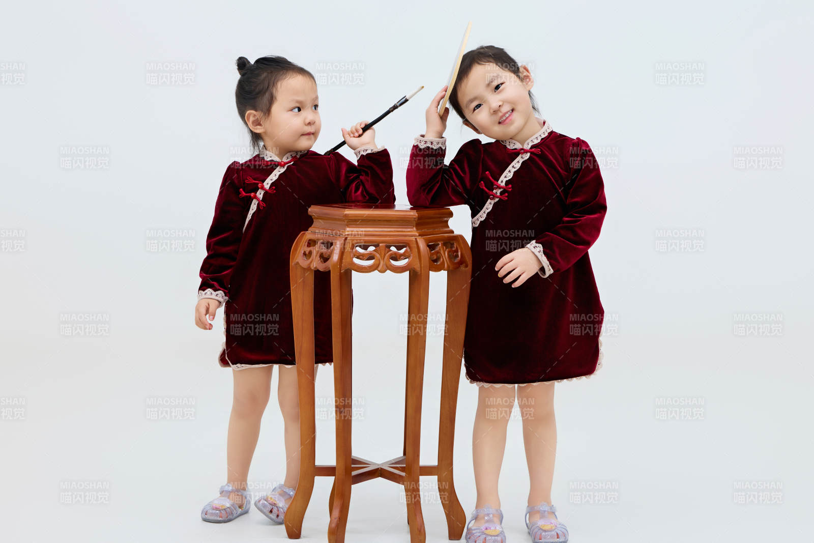 白色背景下顽皮可爱的双胞胎小女孩图片