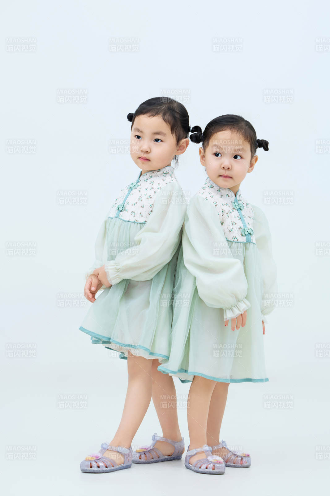 白色背景下顽皮可爱的双胞胎小女孩图片