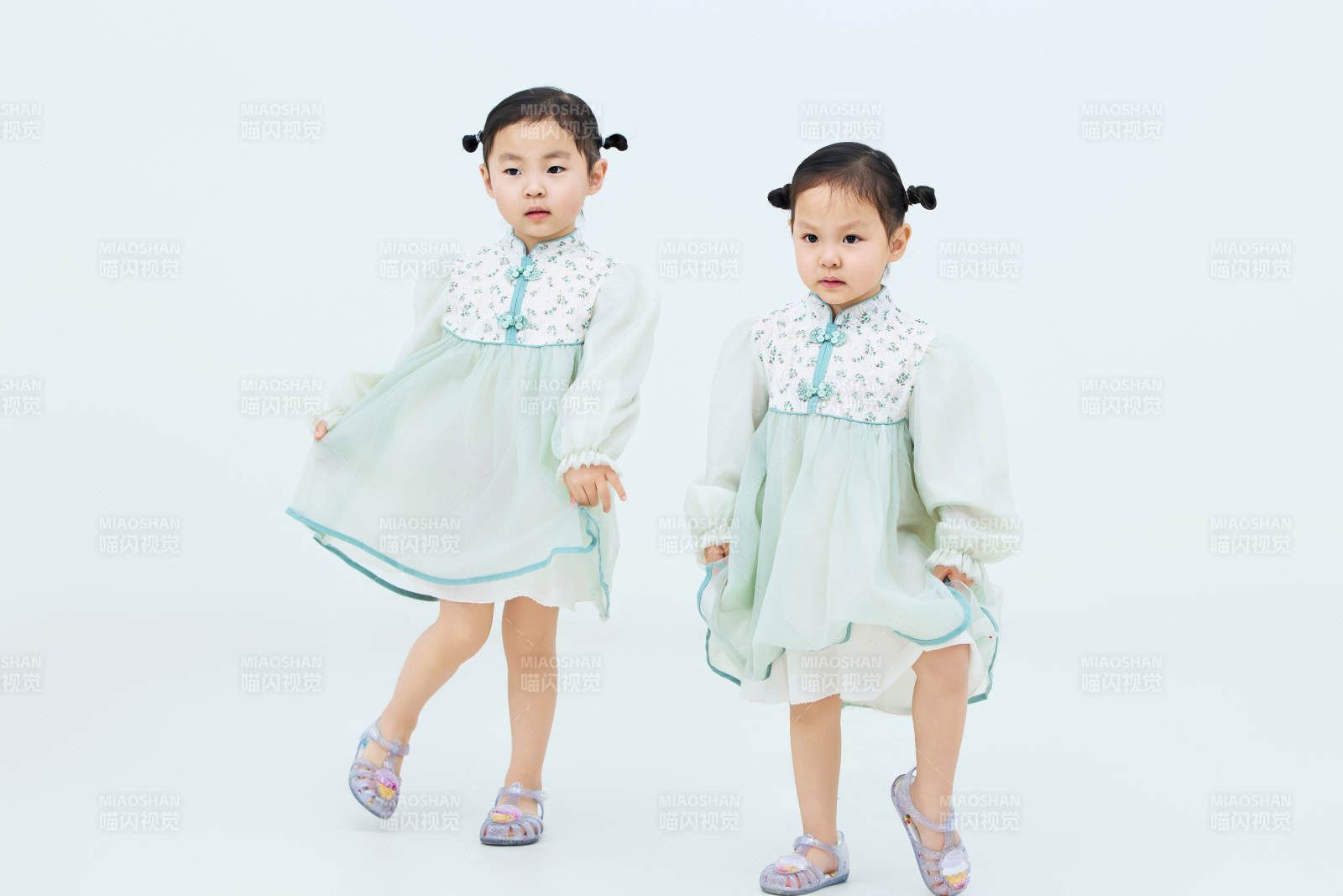 白色背景下顽皮可爱的双胞胎小女孩图片