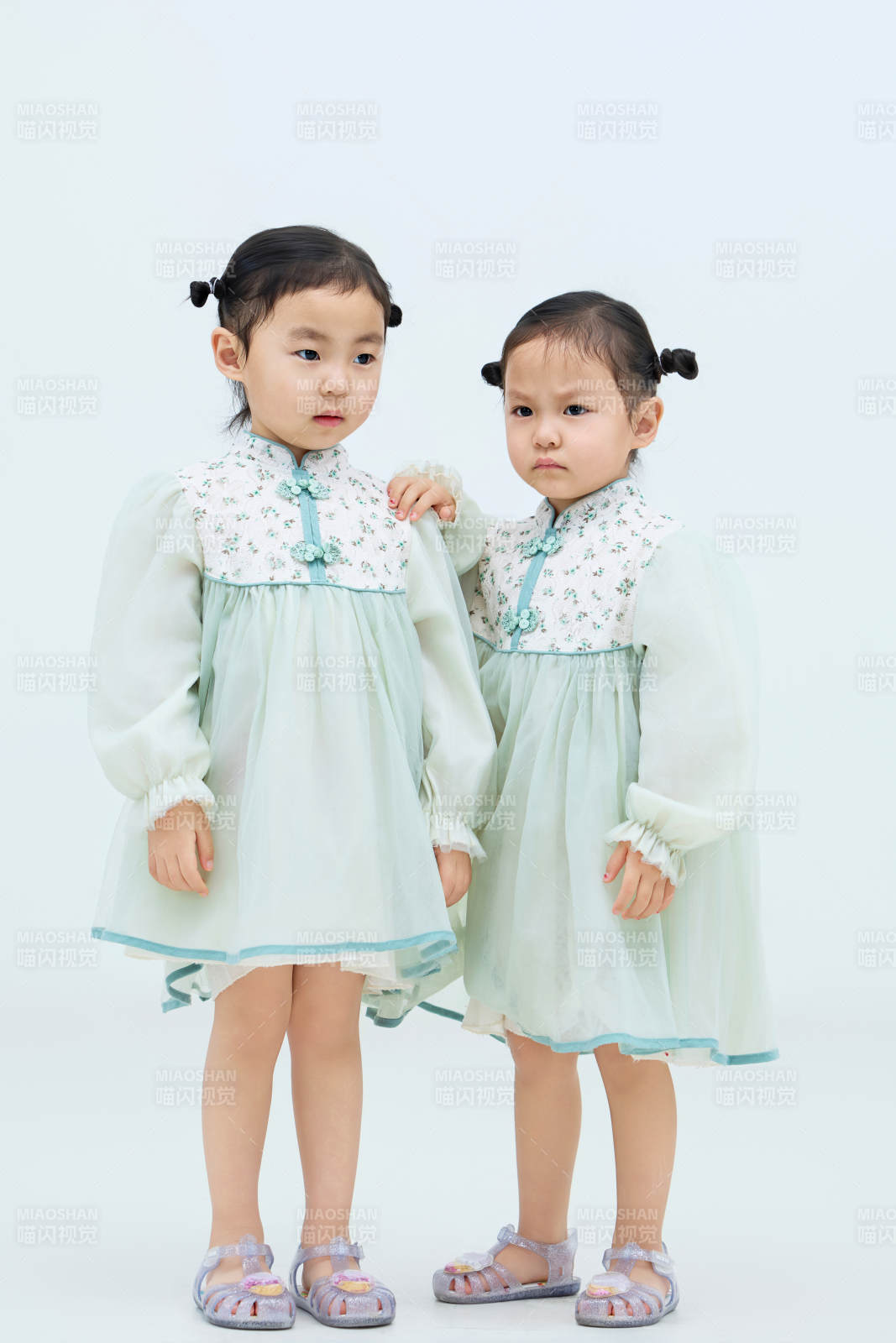 白色背景下顽皮可爱的双胞胎小女孩图片