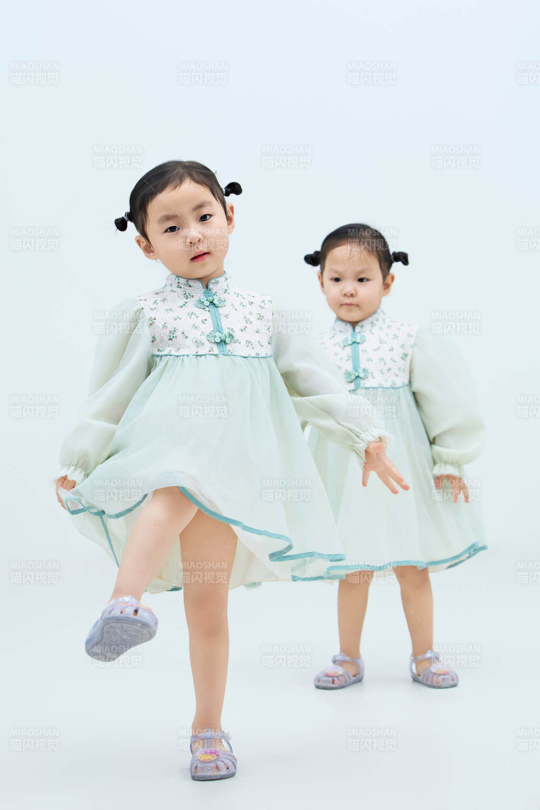 白色背景下顽皮可爱的双胞胎小女孩图片