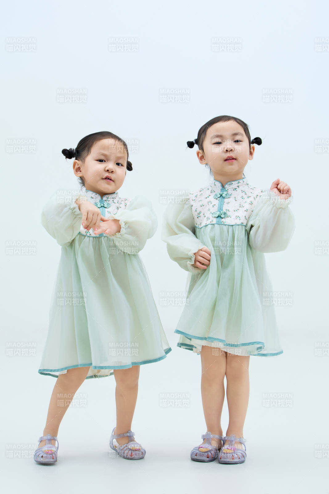 白色背景下顽皮可爱的双胞胎小女孩图片