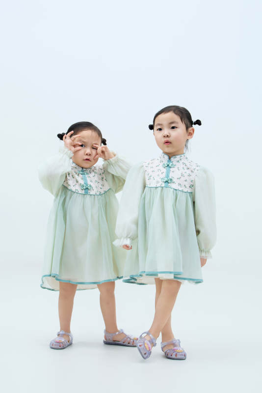 白色背景下顽皮可爱的双胞胎小女孩图片