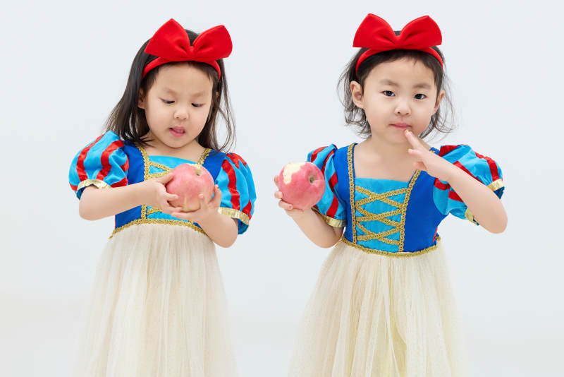 白色背景下顽皮可爱的双胞胎小女孩图片