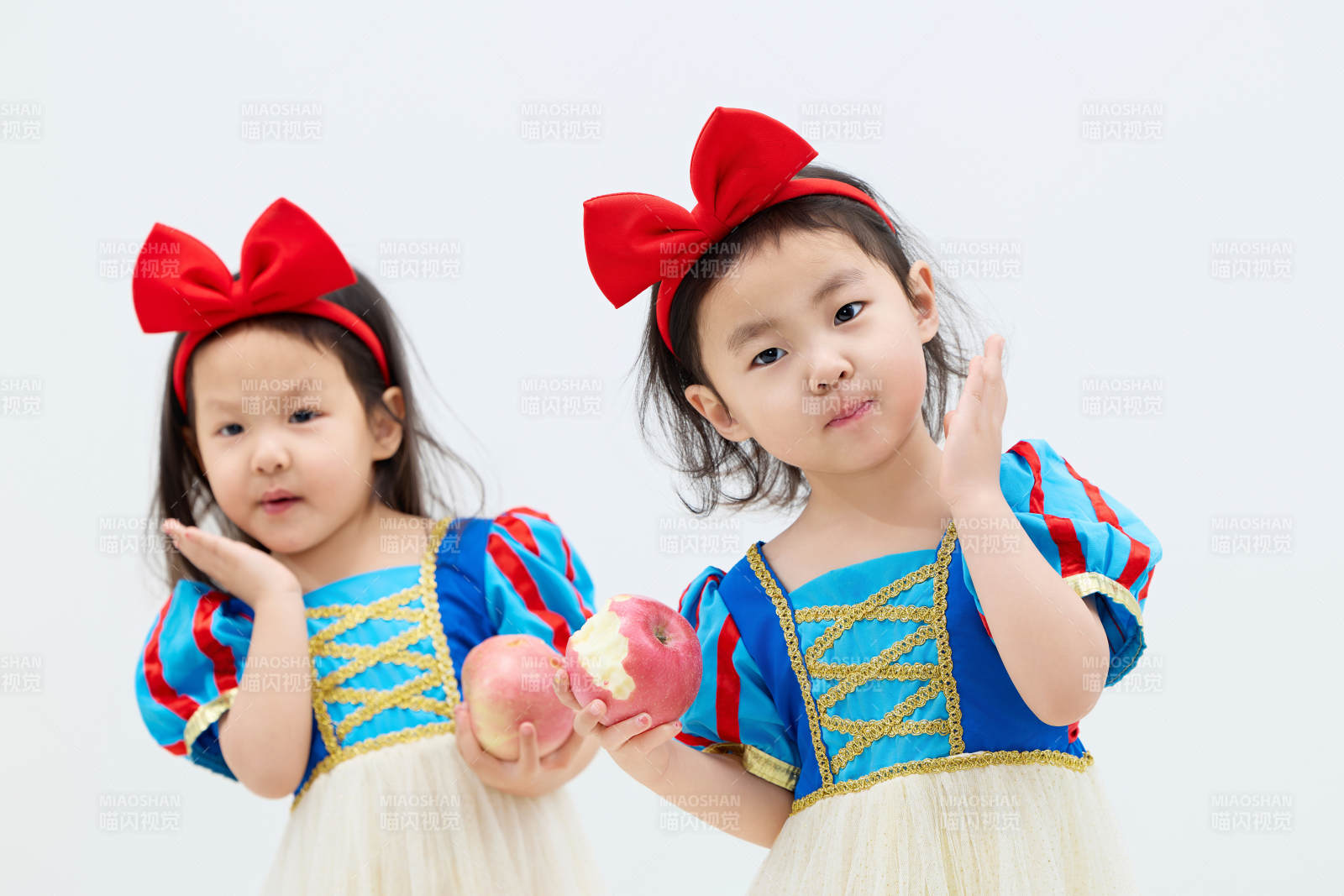 白色背景下顽皮可爱的双胞胎小女孩图片