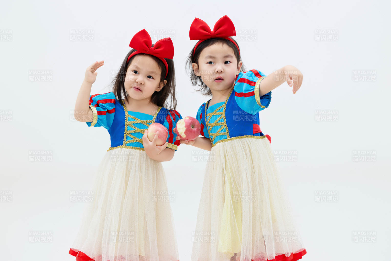 白色背景下顽皮可爱的双胞胎小女孩图片