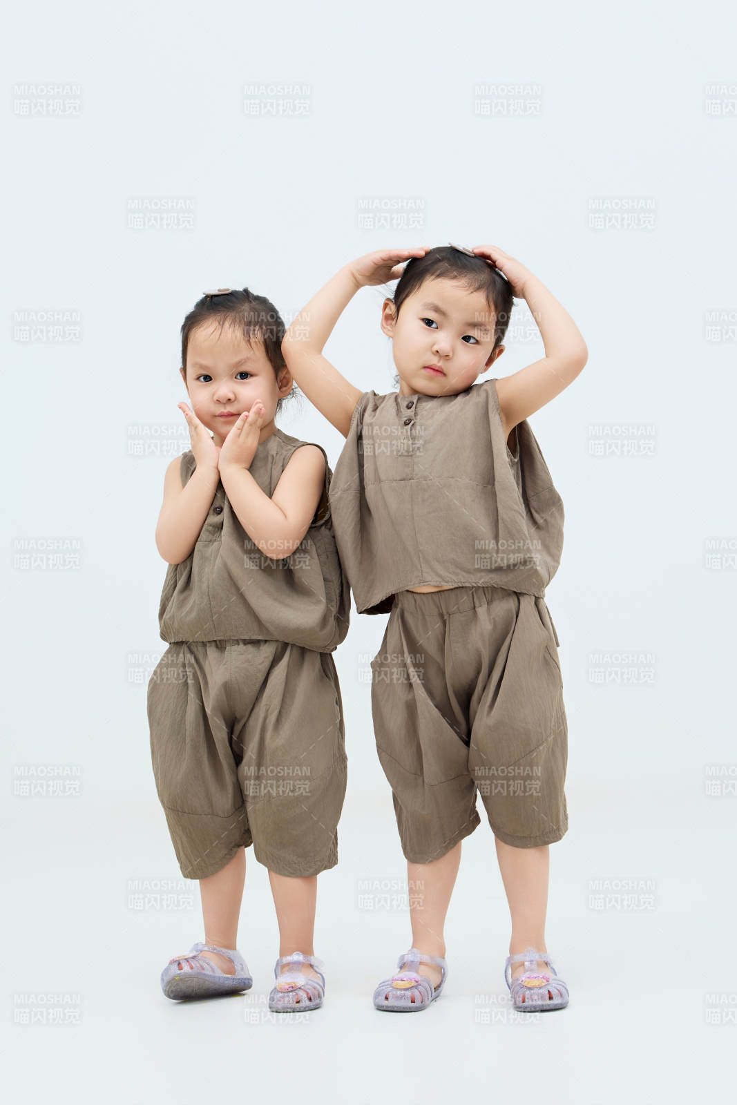 白色背景下顽皮可爱的双胞胎小女孩图片