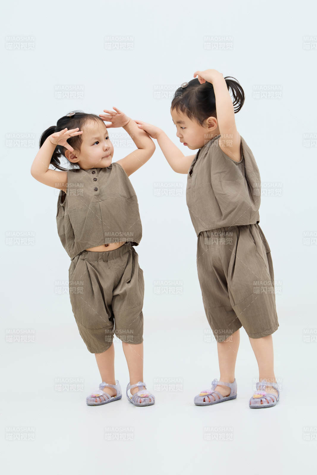 白色背景下顽皮可爱的双胞胎小女孩图片