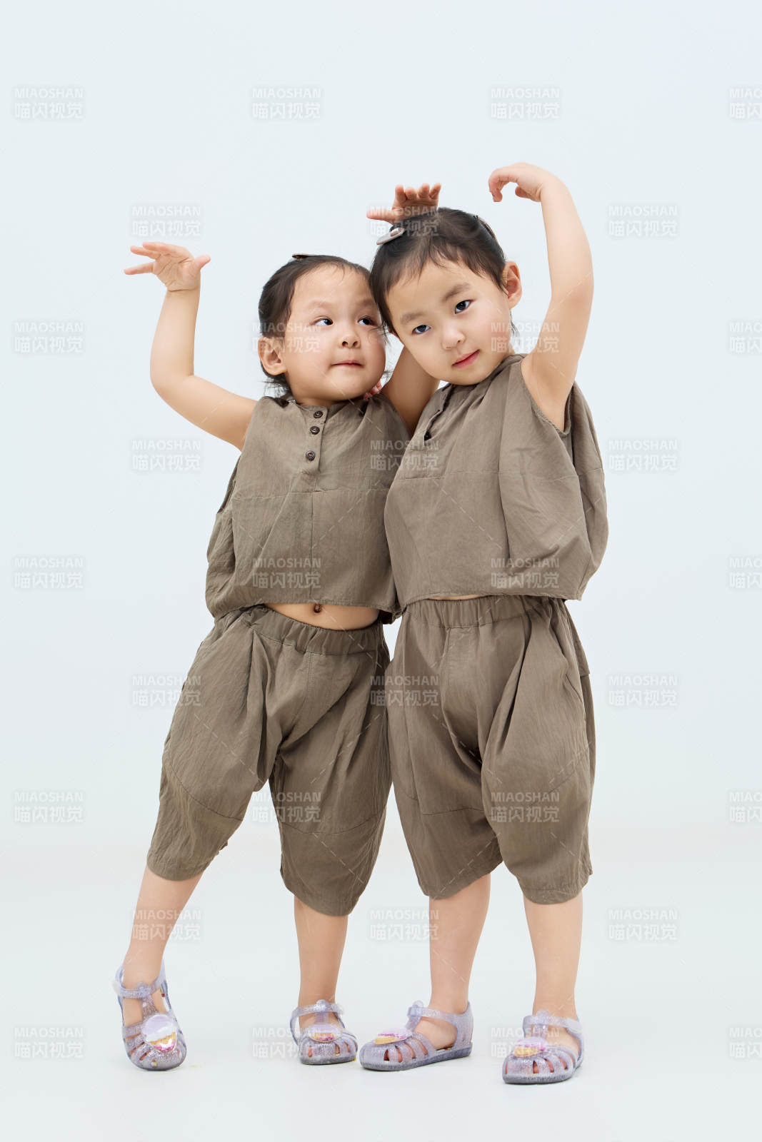 白色背景下顽皮可爱的双胞胎小女孩图片