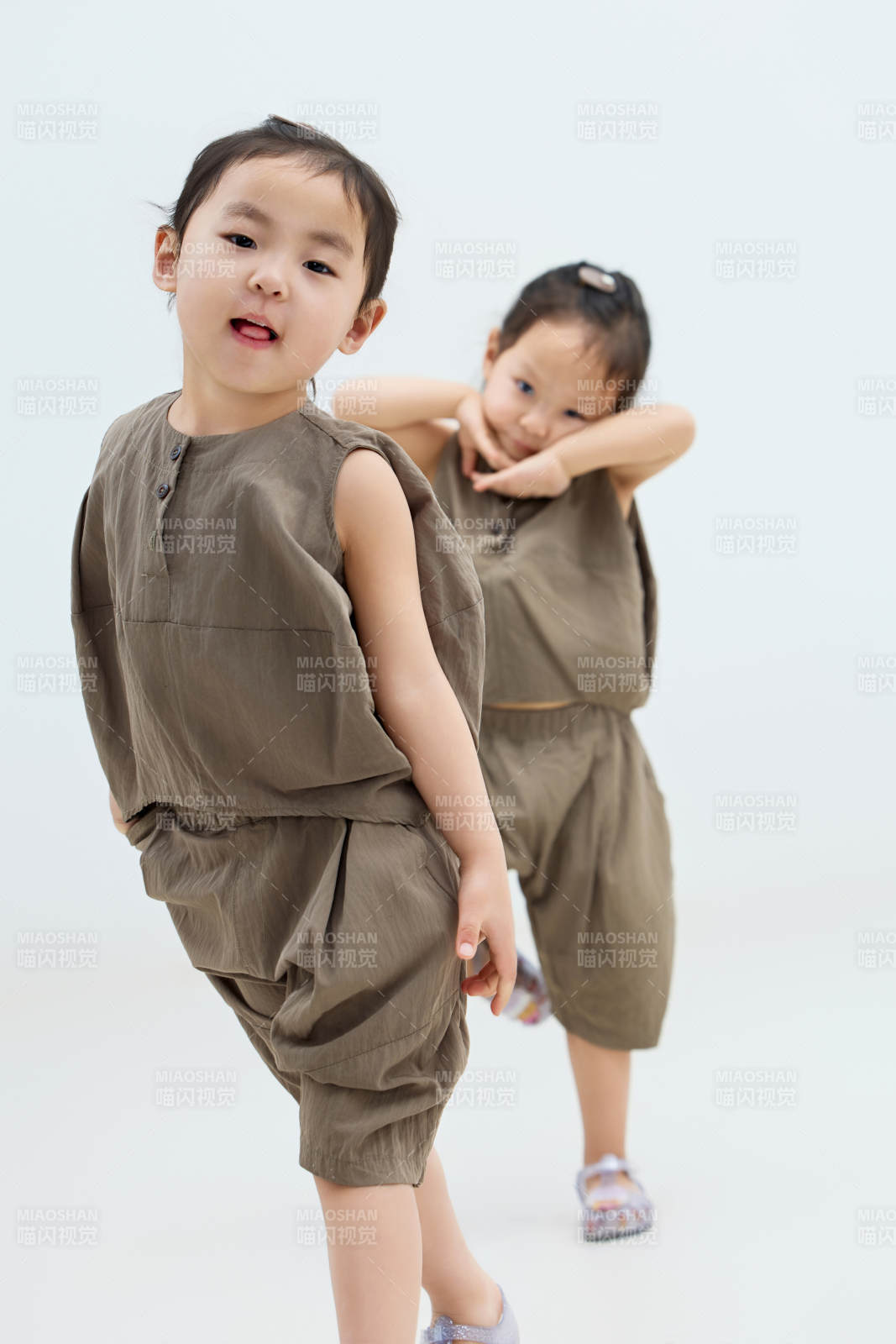 白色背景下顽皮可爱的双胞胎小女孩图片