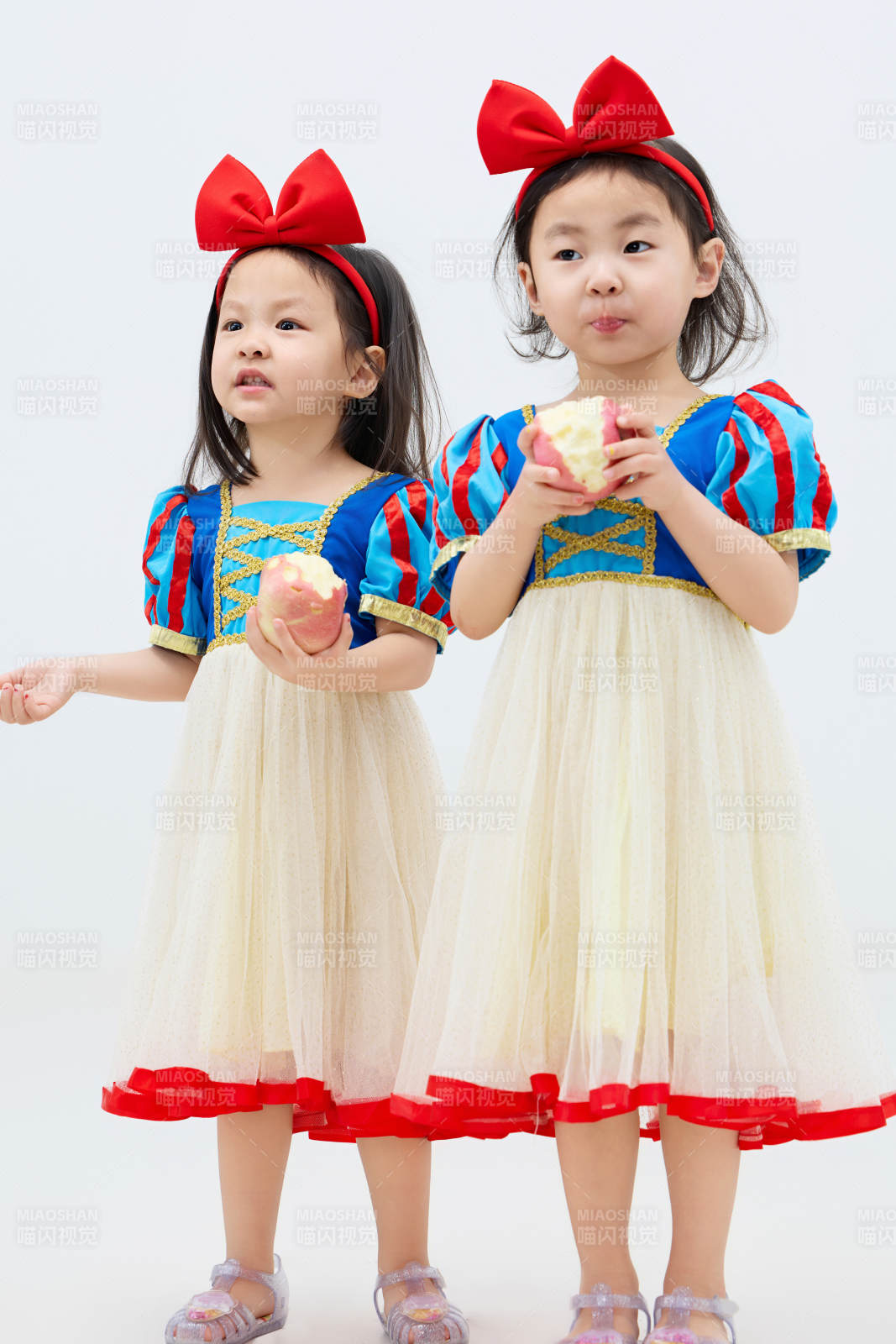 白色背景下顽皮可爱的双胞胎小女孩图片