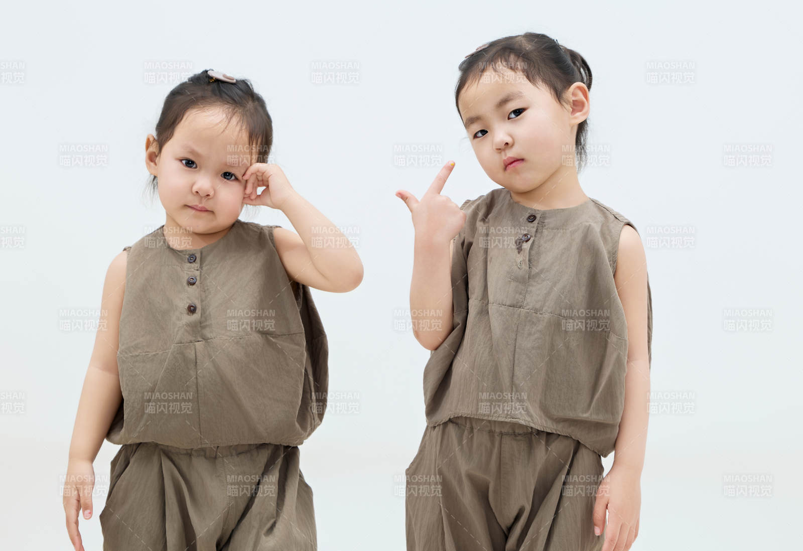 白色背景下顽皮可爱的双胞胎小女孩图片