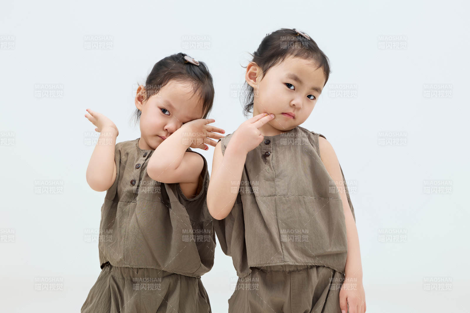 白色背景下顽皮可爱的双胞胎小女孩图片