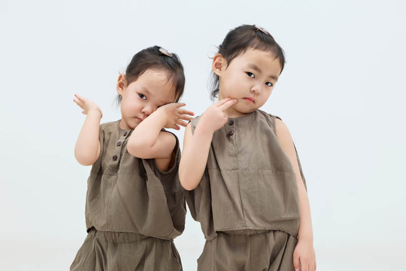 白色背景下顽皮可爱的双胞胎小女孩图片