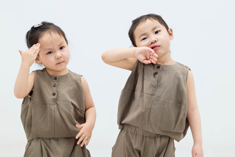 白色背景下顽皮可爱的双胞胎小女孩图片