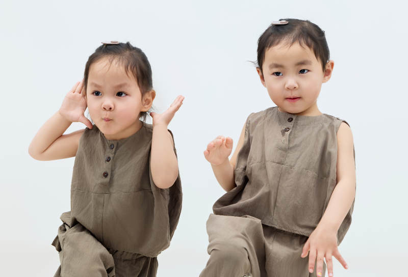 白色背景下顽皮可爱的双胞胎小女孩图片