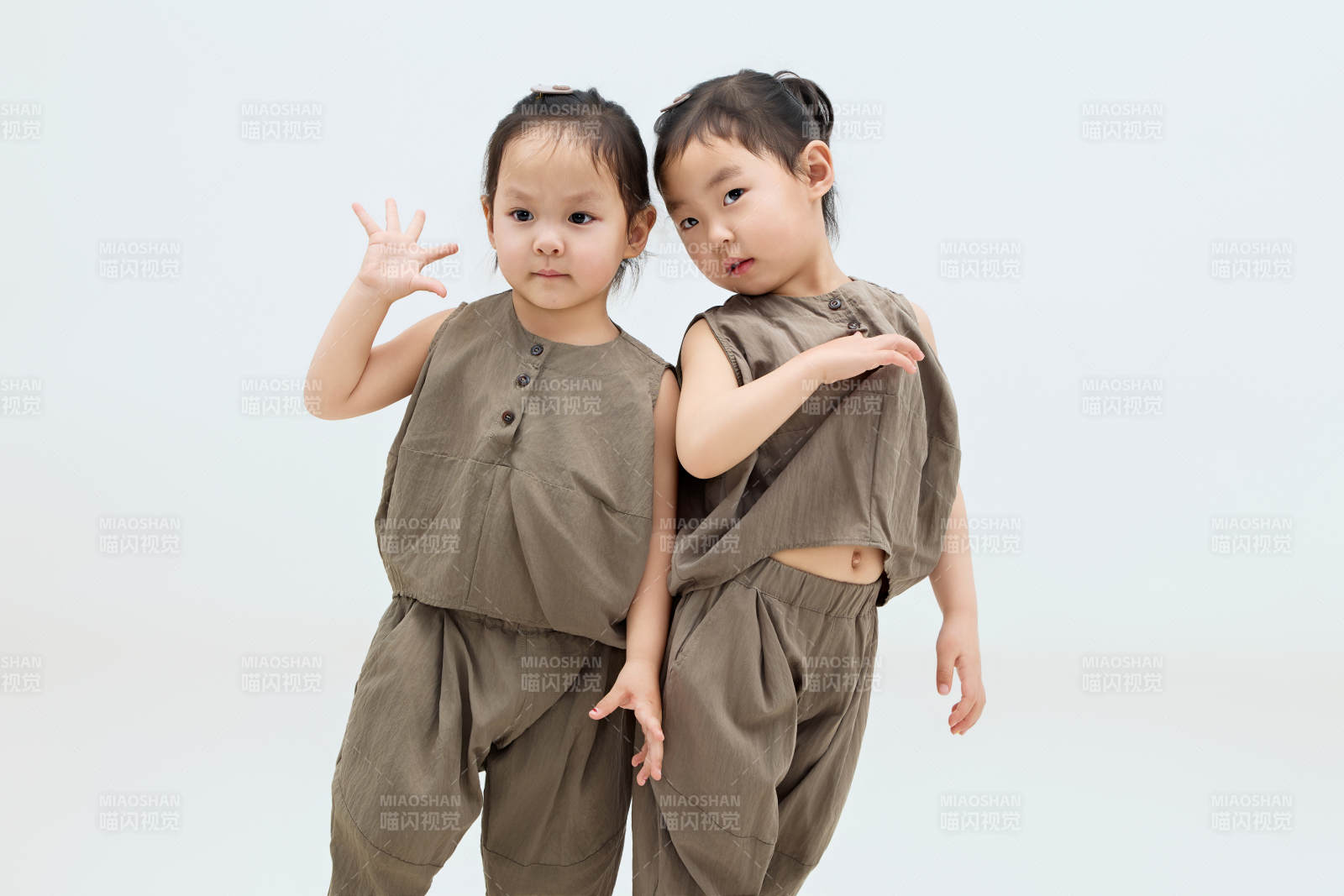 白色背景下顽皮可爱的双胞胎小女孩图片