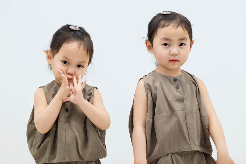 白色背景下顽皮可爱的双胞胎小女孩图片