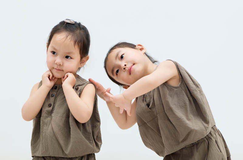 白色背景下顽皮可爱的双胞胎小女孩图片