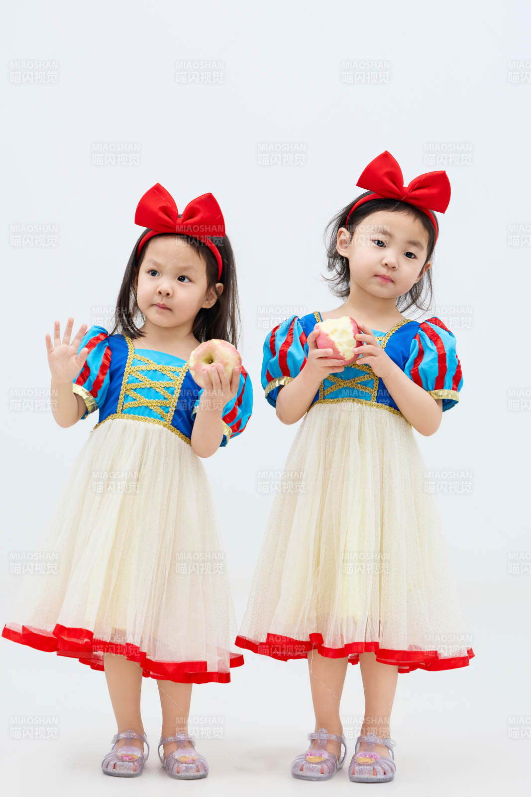 白色背景下顽皮可爱的双胞胎小女孩图片