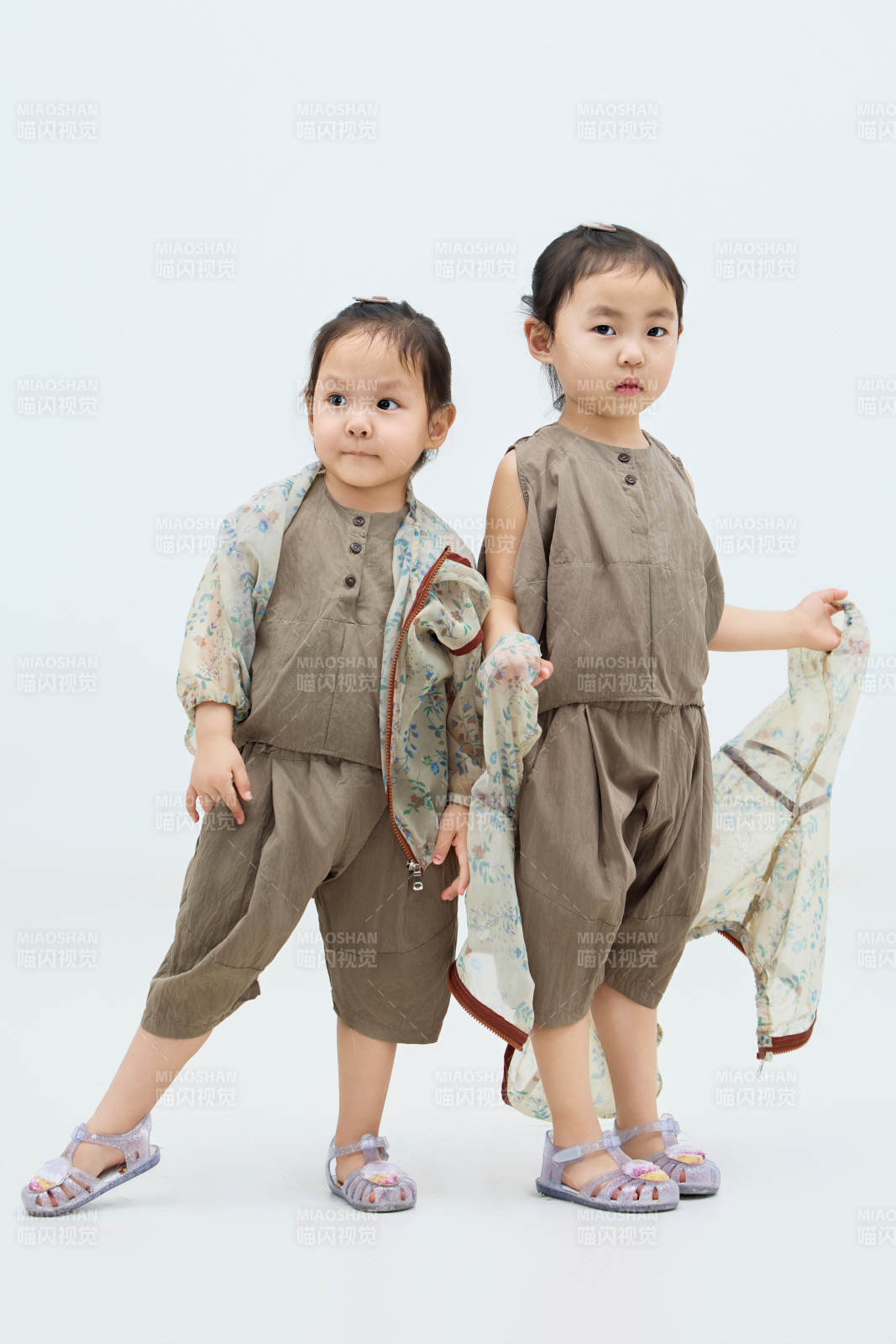 白色背景下顽皮可爱的双胞胎小女孩图片