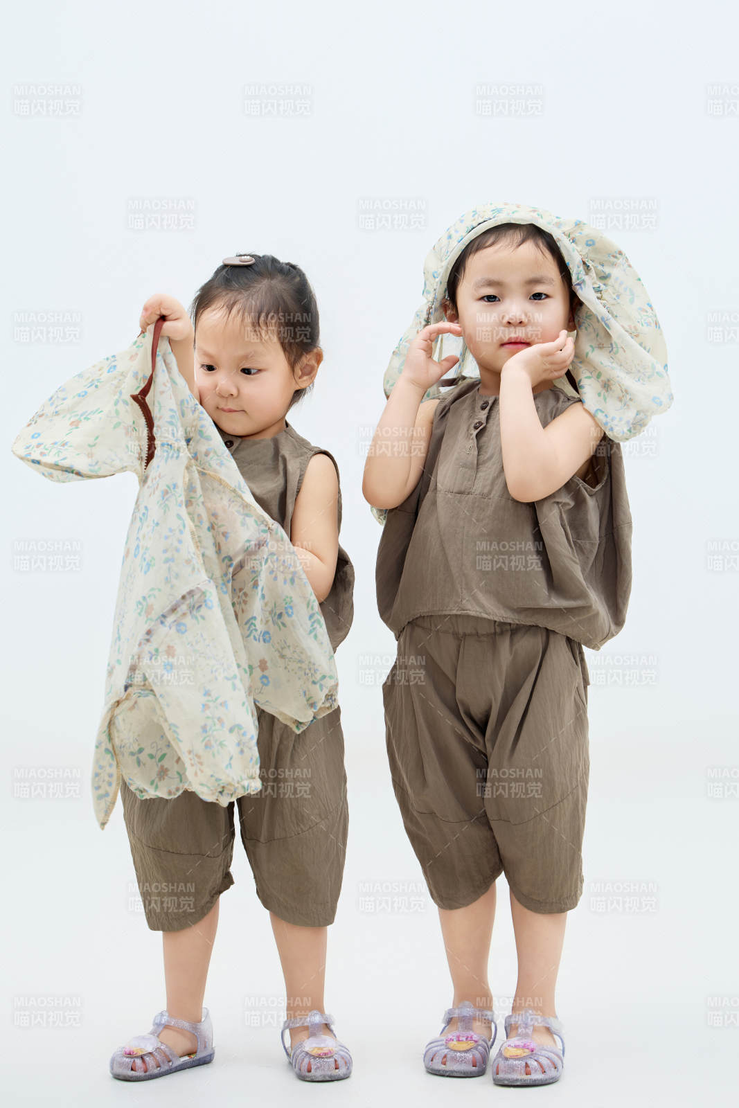 白色背景下顽皮可爱的双胞胎小女孩图片