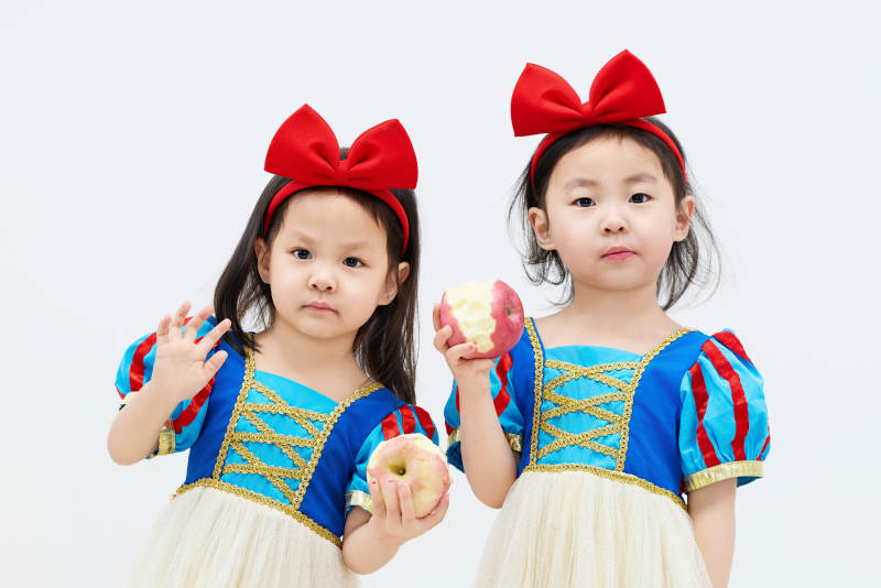 白色背景下顽皮可爱的双胞胎小女孩图片