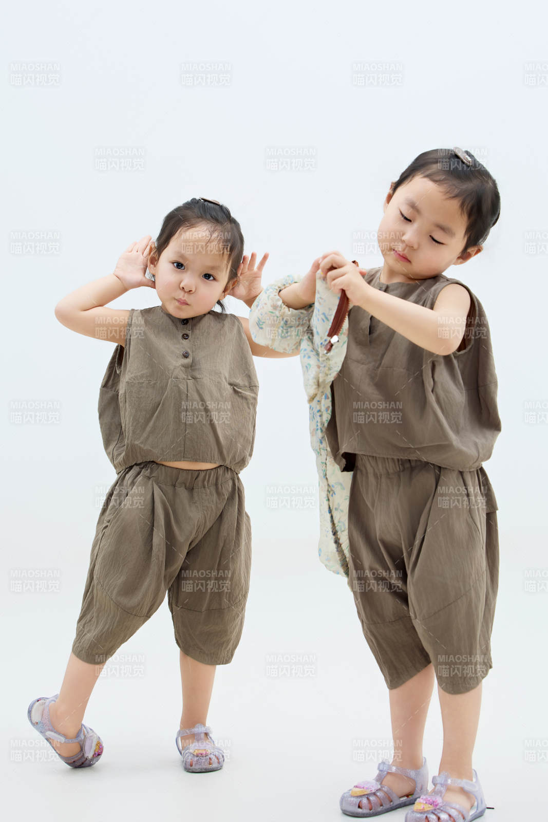 白色背景下顽皮可爱的双胞胎小女孩图片