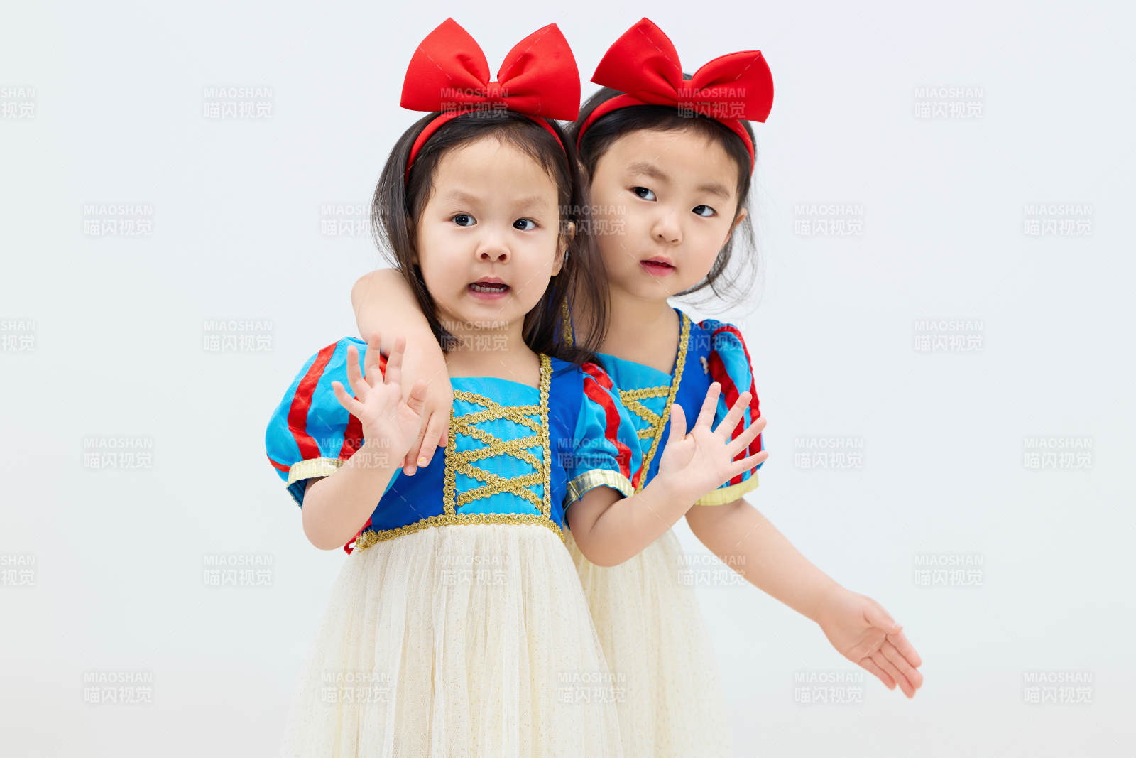 白色背景下顽皮可爱的双胞胎小女孩图片
