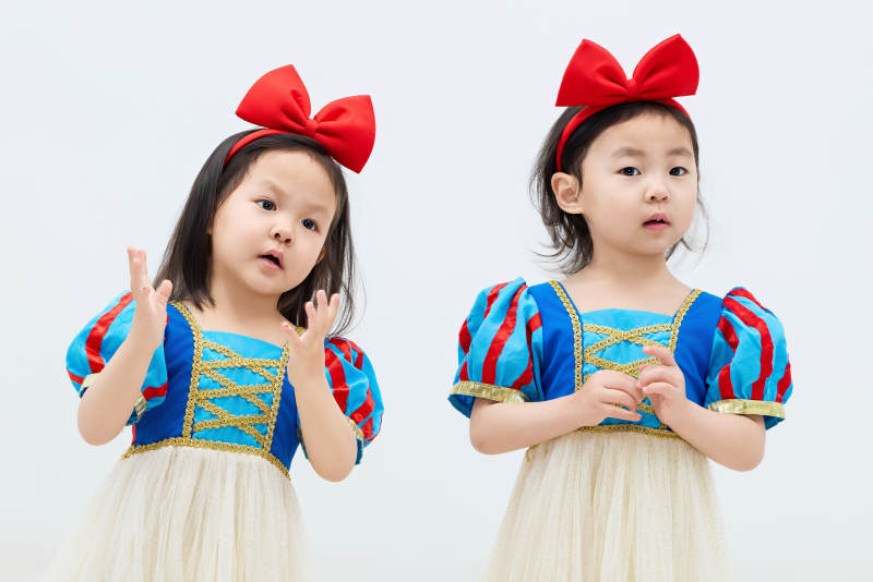 白色背景下顽皮可爱的双胞胎小女孩图片