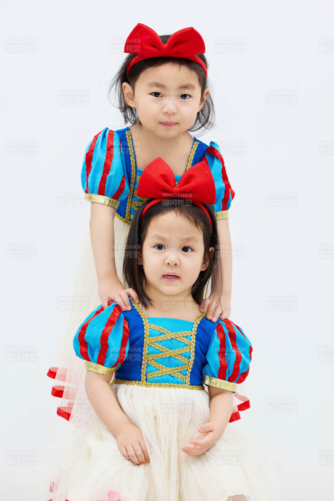 白色背景下顽皮可爱的双胞胎小女孩图片