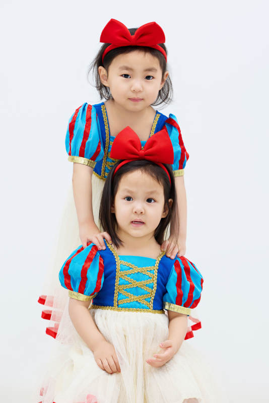 白色背景下顽皮可爱的双胞胎小女孩图片