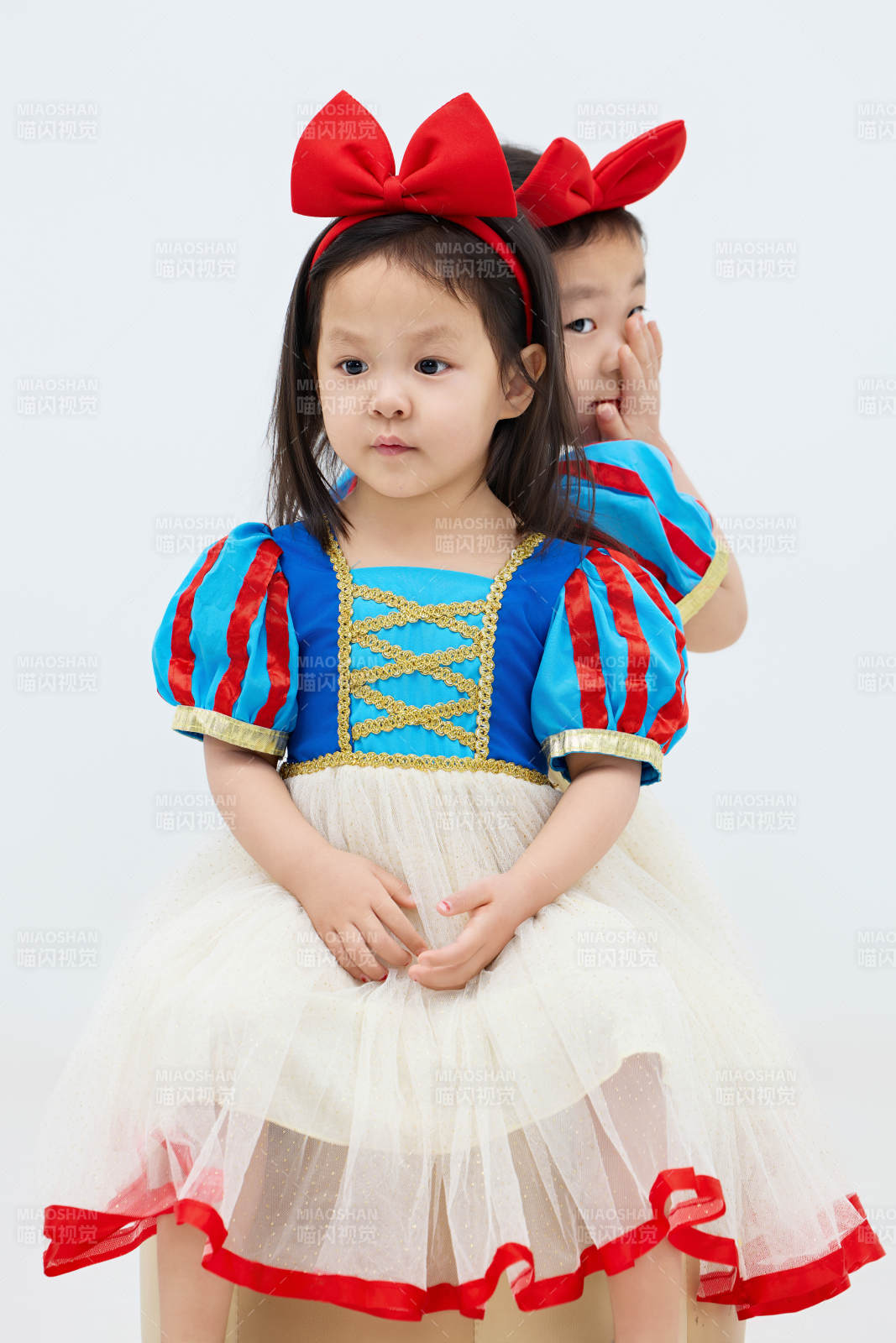 白色背景下顽皮可爱的双胞胎小女孩图片