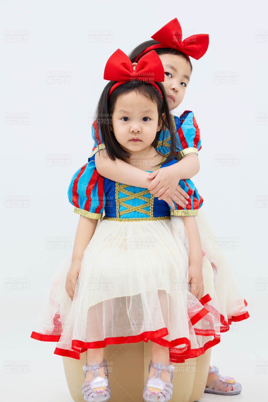 白色背景下顽皮可爱的双胞胎小女孩图片
