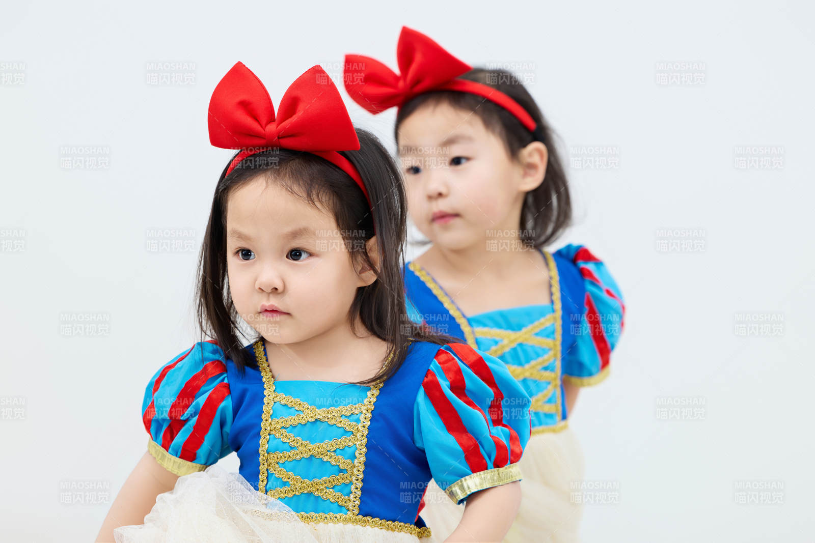 白色背景下顽皮可爱的双胞胎小女孩图片