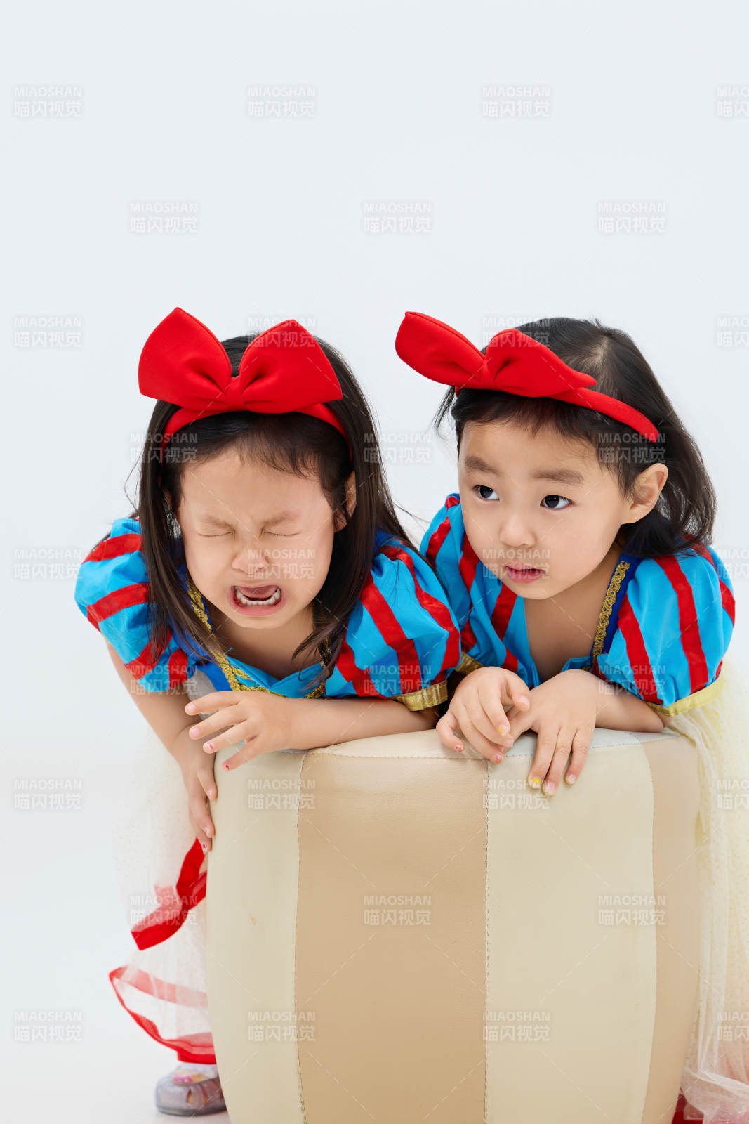 白色背景下顽皮可爱的双胞胎小女孩图片