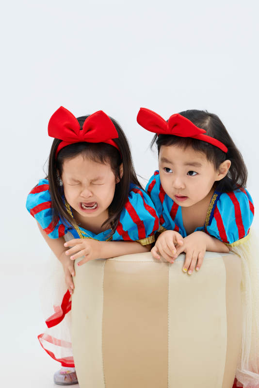 白色背景下顽皮可爱的双胞胎小女孩图片